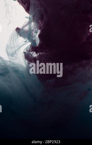 une belle image d'un liquide rose et torquoise coloré se mélangeant dans l'eau, motif abstrait Banque D'Images