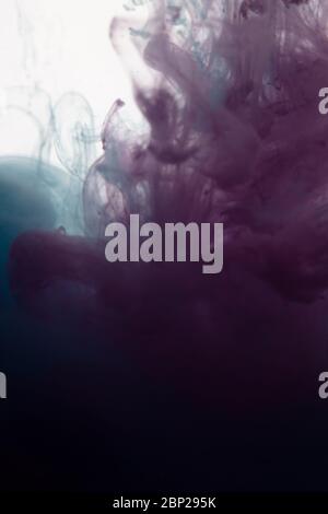 une belle image d'un liquide rose et torquoise coloré se mélangeant dans l'eau, motif abstrait Banque D'Images