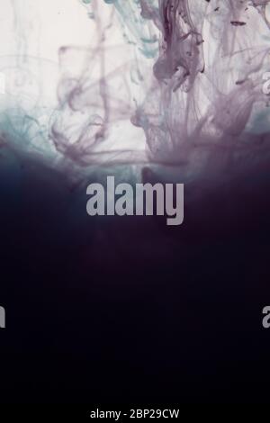 une belle image d'un liquide rose et torquoise coloré se mélangeant dans l'eau, motif abstrait Banque D'Images