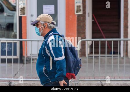 Montréal, CA - 16 mai 2020 : homme avec masque pour la protection contre la COVID-19 en descendant la rue Banque D'Images