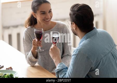 Joyeux jeune couple boire du vin Profitez de la date dans la cuisine maison Banque D'Images