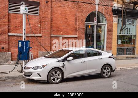 Montréal, CA - 16 mai 2020 : la voiture électrique de la Volt de Chevrolet est branchée à une station de charge de véhicule électrique Banque D'Images