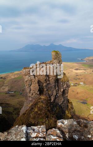 Sgorr an Fharaidh est la colline au-dessus de Cleadale sur Eigg et a un affleurement rocheux appelé le doigt de Dieu, Rum peut être vu au loin. Banque D'Images