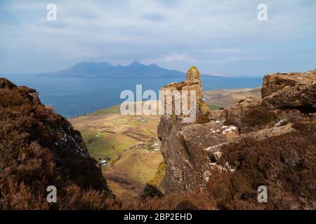 Sgorr an Fharaidh est la colline au-dessus de Cleadale sur Eigg et a un affleurement rocheux appelé le doigt de Dieu, Rum peut être vu au loin. Banque D'Images