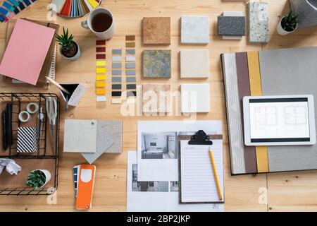 Vue de haut en bas de la collection d'échantillons, de photos, de croquis, de palettes et d'autres fournitures de papeterie pour le travail de designer d'intérieur moderne Banque D'Images