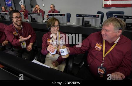 Mars InSight Landing Sue Strekar, chercheur principal adjoint InSight, NASA JPL, centre, Et Charles Scott, directeur adjoint de projet Insight, NASA JPL, dit acclamer avec deux pots de bonne chance cacahuètes comme Thomas Thammasuckdi, ingénieur des systèmes logiciels, NASA JPL, à gauche, regarde, lundi 26 novembre 2018 dans la zone de soutien de mission au Jet propulsion Laboratory de la NASA à Pasadena, Californie. Insight, qui est une courte exploration intérieure utilisant les investigations sismiques, la géodésie et le transport de chaleur, est un Mars lander conçu pour étudier "l'espace intérieur" de Mars: Sa croûte, le manteau, et le noyau. Banque D'Images