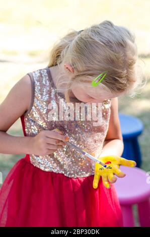 joyeux enfant peint avec une image colorée de pinceau sur sa main et les doigts Banque D'Images