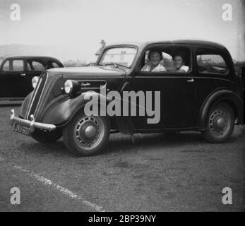 Années 1960, historique, mère et fille assis à l'intérieur d'une voiture Ford Anglia deux portes, une voiture populaire de l'époque. Banque D'Images