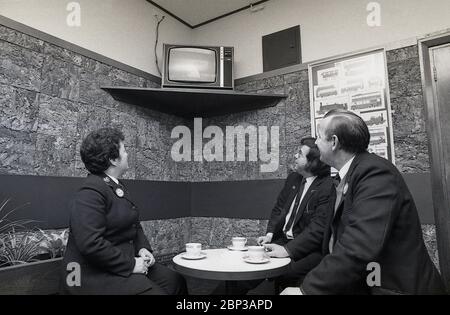 Intérieur, personnel de bus salle de repos New Cross, sud de Londres, Angleterre, 1974, la photo montre trois membres d'équipage en uniforme ayant une pause et une tasse de thé et regardant une petite télévision portable. Banque D'Images