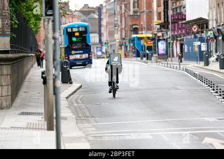 Dublin, Irlande. Mai 2020. Deliveroo Food livrant cycliste traversant la rue vide Nassau dans le centre-ville de Dublin pendant la pandémie Covid-19. Banque D'Images