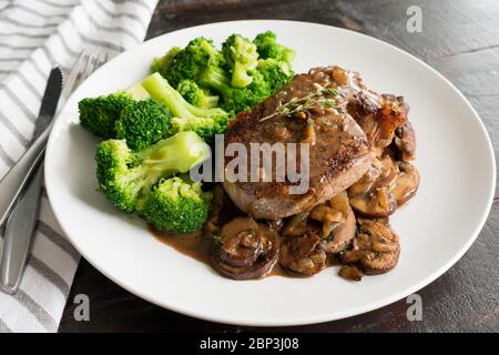 Filet mignon à la sauce au vin de champignons : filet mignon avec une sauce crémeuse aux champignons, servi avec des bouquets de brocoli Banque D'Images