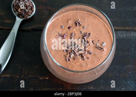 Chocolat pour la nuit, flocons d'avoine, smoothie : un smoothie de petit déjeuner préparé avec des flocons d'avoine, des graines de chia et du lait d'amande Banque D'Images