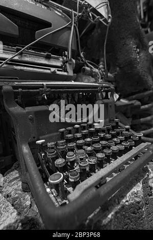 Machine à écrire manuelle vintage cassée sur le sol en noir et blanc. Conceptualiser les auteurs bloc ou une occupation passée n'est plus en usage. Banque D'Images