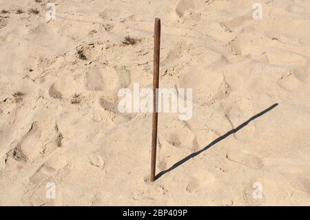 La photo montre un jour ensoleillé, du sable, un bâton de bois dessus. Le cadran solaire indique 2 heures, pause déjeuner. Pause au travail, dans les jeux sportifs. Enfants joués sur le Banque D'Images