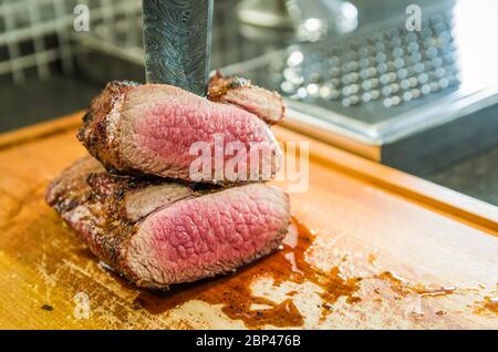 Belle photo de poitrine de boeuf (Brisket point fin). Découpe de viande avec un couteau en acier forgé de Damas de style Arkansas Breeze. Banque D'Images