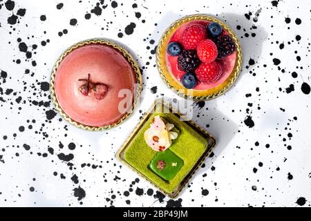 Gâteaux colorés, mousse, gâteau au matcha, garni de baies Banque D'Images
