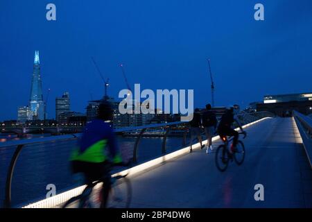 Londres, Royaume-Uni, 17 mai 2020 : les gens traversent le pont de Milemmium et le sommet du Shard est éclairé en bleu. Tate Modern est également doté d'une signalisation indiquant « Merci aux principaux employés » pour honorer le personnel du NHS et les autres travailleurs de soins et les principaux employés de première ligne. Anna Watson/Alay Live News Banque D'Images