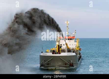 Le dredger Sospan Dau qui pompe se mêle à la plage Banque D'Images