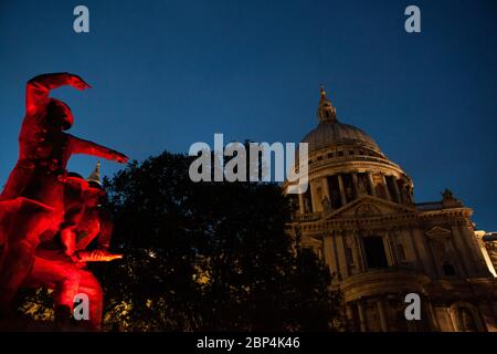 Le mémorial des pompiers, sur le côté sud de la cathédrale Saint-Paul, est éclairé par des lumières rouges clignotantes au crépuscule. Banque D'Images