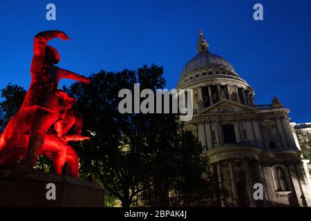 Le mémorial des pompiers, sur le côté sud de la cathédrale Saint-Paul, est éclairé par des lumières rouges clignotantes au crépuscule. Banque D'Images