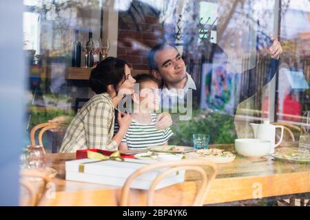 Une famille heureuse de trois selfies dans un café Banque D'Images