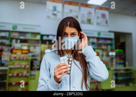 La femme montre des pilules, des vitamines ou des pilules dans sa main. Covid-19. Banque D'Images