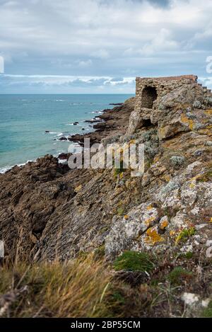 Ruines d'une tour au sommet d'une falaise côtière en Bretagne, en France, pendant une journée nuageux. Banque D'Images