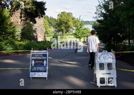 Le panneau dans un parc rappelle aux gens de pratiquer la distance sociale, car plusieurs aires de loisirs et parcs de l'Oregon rouvrent avec un accès limité à la journée. Banque D'Images