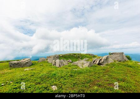 immense pierre dans la vallée sur le sommet de la crête de montagne. paysage d'été de montagne. pré avec des pierres énormes au milieu de l'herbe sur le sommet de la colline près du pois Banque D'Images