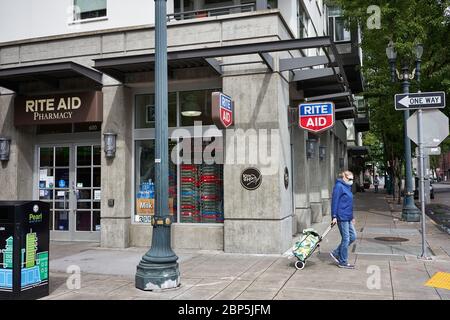 Un vieux masqué passe devant une pharmacie RITE AID dans le quartier Pearl de Portland, Oregon, le vendredi 15 mai 2020. Banque D'Images