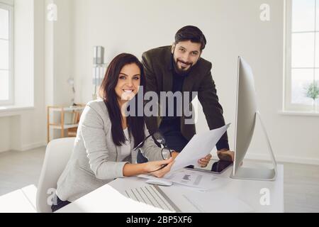 L'équipe Business People Partners analyse les graphiques de statistiques de travail dans l'ordinateur à la table au bureau. Banque D'Images