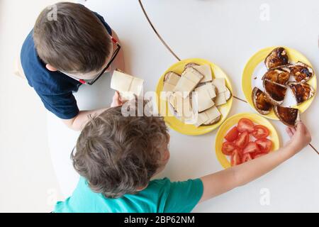 Dresde, Allemagne. 18 mai 2020. Deux enfants s'assoient à la table pour le petit déjeuner dans un jardin d'enfants. Après des semaines de pauses obligatoires de Corona, les enfants sont maintenant autorisés à rentrer dans les crèches et les garderies. Credit: Sebastian Kahnert/dpa-Zentralbild/dpa/Alay Live News Banque D'Images