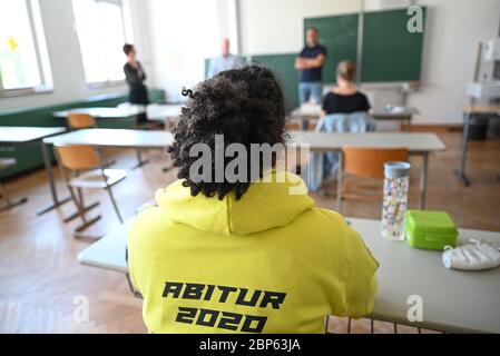 Ravensburg, Allemagne. 18 mai 2020. Un étudiant du Albert-Einstein-Gymnasium étudie les devoirs d'examen d'Abitur. Pour la première fois, les examens Abitur commencent avec le sujet espagnol. Au total, trois élèves ont passé l'examen espagnol Abitur au Albert-Einstein-Gymnasium. Sur le devant de leur sweat-shirt à capuche, il dit : « Corona Abi - J'ai séjourné chez moi, je l'ai toujours eu ». Au dos, il dit : 'Abitur 2020.' Credit: Felix Kästle/dpa/Alay Live News Banque D'Images