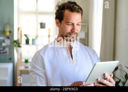 Portrait de l'homme en vue avant avec une tablette à la maison. Banque D'Images