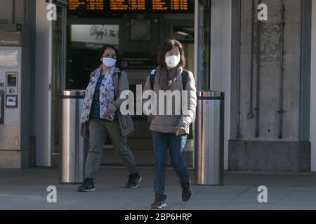 WIMBLEDON LONDRES, 18 mai 2020. ROYAUME-UNI. Les navetteurs portant des masques faciaux protecteurs contre les infections à Covid-19 émergent de la gare de Wimbledon le matin. Les services ferroviaires devraient être augmentés à 70 pour cent des niveaux normaux et la police des transports britannique devrait patrouiller les stations de métro et de ligne principale de Londres afin d'éviter le surpeuplement. Crédit : amer ghazzal/Alay Live News Banque D'Images