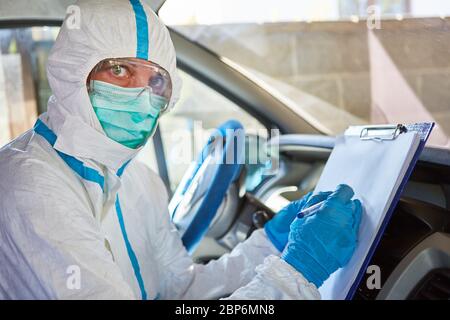 Paramédic comme scout de confinement avec liste pour le suivi des contacts dans l'ambulance en cas de pandémie de coronavirus Banque D'Images