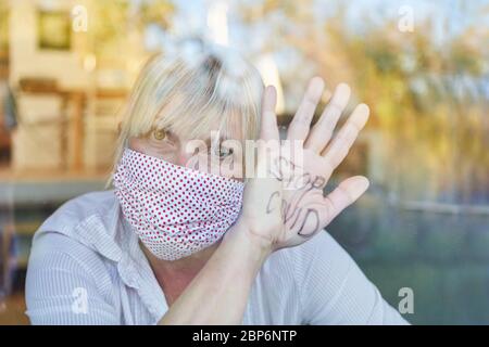Arrêtez les messages Covid sur la paume d'un citoyen âgé avec un garde-bouche en quarantaine en cas de pandémie du coronavirus Banque D'Images