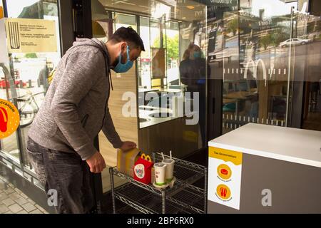 Lviv, Ukraine - 17 mai 2020 : restaurant McDonalds, homme prenant sa commande sans aucun effort. Concept de soins de santé et de distance sociale, réouverture. Sélectionnez Banque D'Images