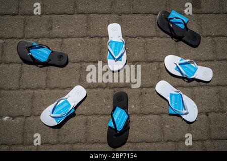 ROSTOCK (WARNEMÜNDE), ALLEMAGNE - 25 juillet 2019 : tongs se trouvent sur le trottoir en un demi-cercle. Campagne de publicité inhabituelle magasin de chaussures. Banque D'Images