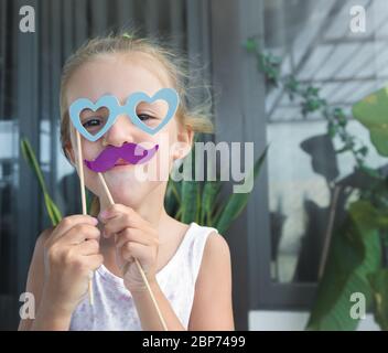 Portrait de petite fille drôle avec des accessoires en papier Banque D'Images