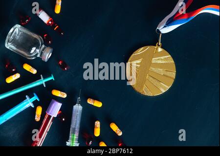 Médaille d'or et médicaments, seringue et bouteille de médecine pour injection. Dopage dans le sport, espace de montage noir Banque D'Images