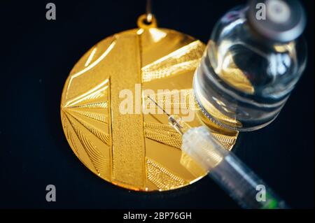 Médaille d'or, seringue et flacon de médecine pour injection. Dopage dans le sport, espace de montage noir Banque D'Images