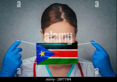 Coronavirus au Soudan du Sud Femme Portrait tenir protéger le visage masque médical chirurgical avec drapeau national du Soudan du Sud. Maladie, virus Covid-19 dans S Banque D'Images