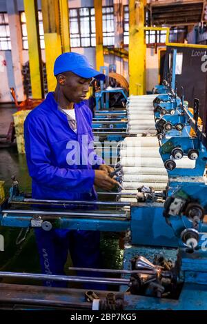 Johannesburg, Afrique du Sud - 16 octobre 2012 : ouvrier d'usine africain sur un métier à tisser de ligne de montage de trame de cobobineuse Banque D'Images