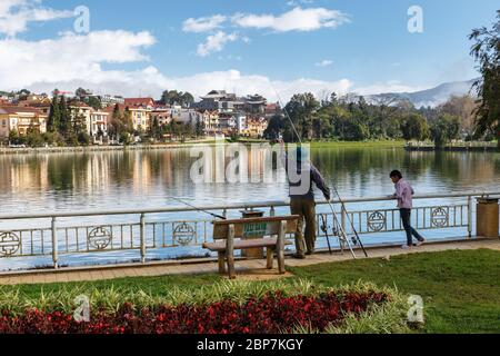 Sa Pa, Vietnam - 20 novembre 2018 : homme vietnamien avec son fils pêchant sur le lac de la ville. Lac sa Pa. Banque D'Images