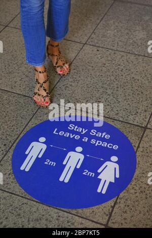 La signalisation sur le métro de Londres rappelle aux navetteurs la distance sociale pendant la pandémie du coronavirus. Gare de Westminster. Mai 2020 Banque D'Images