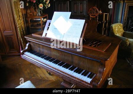 Piano ancien dans une salle avec mobilier d'époque sur parquet Banque D'Images