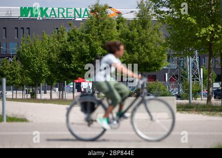 Augsbourg, Allemagne. 16 mai 2020. Un cycliste passe devant la WWK Arena. Le jeu FC Augsburg - VfL Wolfsburg, comme tous les matchs de la Ligue allemande de football, se joue sans spectateurs en raison de la pandémie de Corona. Crédit : Tom Weller/dpa/Alay Live News Banque D'Images