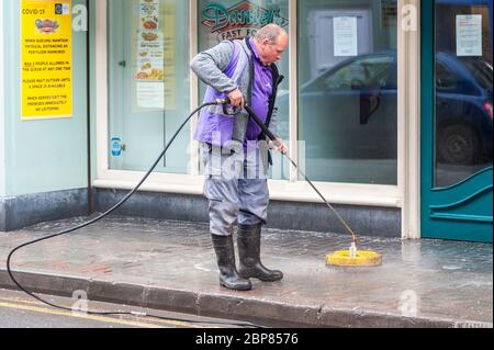 Bandon, West Cork, Irlande. 18 mai 2020. Ce matin, Bandon a fait nettoyer la rue principale en profondeur, dans le cadre de la phase de « retour aux affaires » de sortie du confinement de Covid-19, Soft Clean Group a été chargé d'effectuer la tâche à Bandon. Robert Healy, un employé, doux nettoie la rue. Crédit : AG News/Alay Live News Banque D'Images