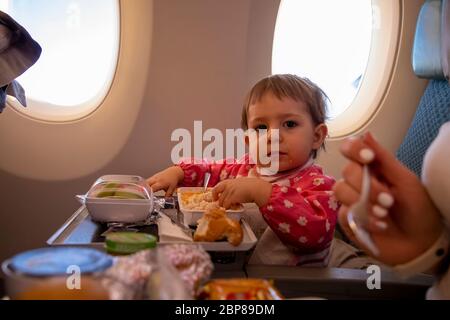 un petit passager mange dans un repas spécial avion. un jeune voyageur en bas âge Banque D'Images